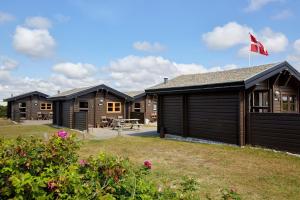a row of lodges with a canadian flag on top at Fjand Badeby - Guesthouse, Cottages and Colony in Ulfborg