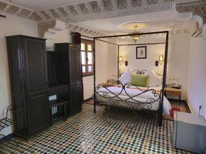 a bedroom with a canopy bed and a mirror at Riad Fes Bab Rcif Suite &Spa in Fez +119 photos