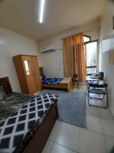 a bedroom with a bed and a desk and a table at Adbldna01 in Abu Dhabi
