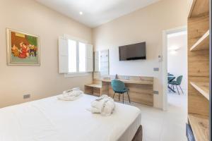 Un dormitorio con una cama y un televisor en la pared. en Dimora Suite Idro, en Gallipoli