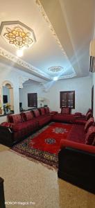 a living room with a couch and a rug at Bel appartement familial au centre ville in El Kelaa des Srarhna