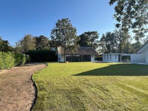 una casa con un cortile erboso accanto a un edificio di Guesthouse 'Elements' with panoramic views a Bergen