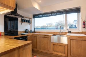 a kitchen with a sink and a large window at Port View House 3-Bedroom Self Catering Family Home with Garden Near Cardiff in Cardiff