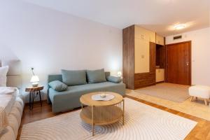 een woonkamer met een bank en een tafel bij Pirin Sense Mountain Paradise Escape - SPA - Free Parking in Bansko