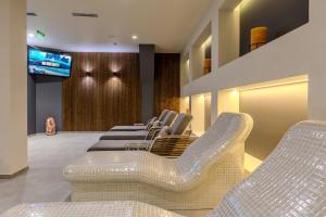 een wachtkamer met witte stoelen en een televisie bij Pirin Sense Mountain Paradise Escape - SPA - Free Parking in Bansko