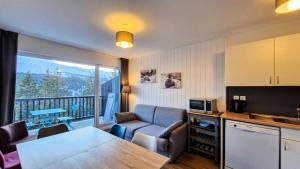 salon ze stołem oraz kuchnia z balkonem w obiekcie Résidence Les Pleiades - Appartement rénové · Centre station · Balcon · Parking couvert MAE-8234 w mieście Magland