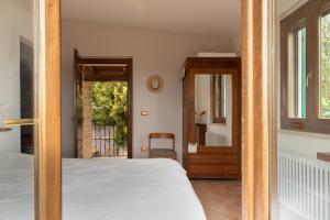a bedroom with a bed and a mirror and a door at Agriturismo Angeli Sognanti in Cossignano +25 photos