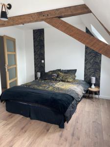1 dormitorio con cama negra y techo de madera en l'ADRESSE, en Bergues