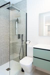a bathroom with a toilet and a glass shower at Apartamento Molino y GARAJE in Ronda