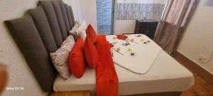 Una cama con almohadas rojas encima. en Neo & Ruks Guest House Boston Belleville 9, en Bellville