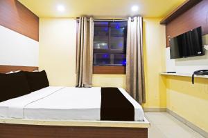 a bedroom with a large bed and a window at Hotel O Atithi Restro And Cafe in Dhanbād