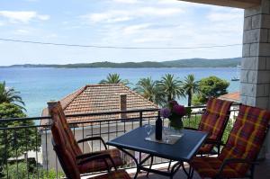 einen Tisch auf einem Balkon mit Blick auf das Wasser in der Unterkunft Apartments Zdravko in Orebić