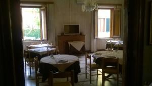 a dining room with tables and chairs and windows at Da Beppe in Chiesina Uzzanese