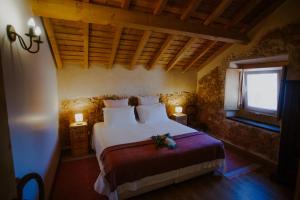a bedroom with a bed with a flower arrangement on it at Aba da Serra - Turismo Rural in Abrigada +36 photos