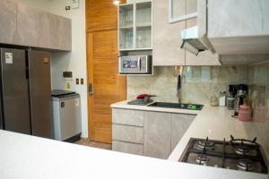 a kitchen with a stove and a refrigerator at Hotel Vista Verde in Campoverde