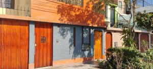un grupo de edificios con puertas naranjas. en Posada Estela, en Lima
