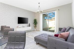 a living room with a couch and a tv at 4BD/3BA Champions Gate Home With Private Pool in Davenport