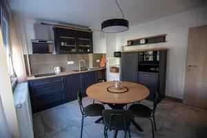 a small kitchen with a wooden table and chairs at FIVE apartment - very center in Osijek