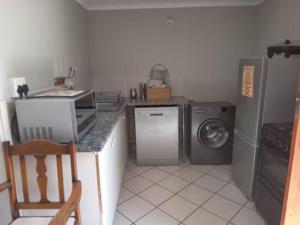cocina con lavadora, lavadora y secadora en Club Med 23, en Hibberdene