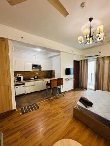 a large living room with a bed and a kitchen at Studio Apartment by Serenity Homes in Noida in Noida