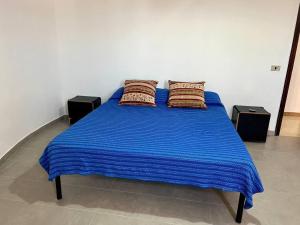 a blue bed with two pillows on top of it at Sobrado no Jardim Eldorado in Paranaguá