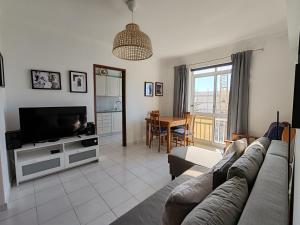 a living room with a couch and a television at 4C Atlantico 1 - Casas & Papeis in Armação de Pêra