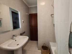 a white bathroom with a sink and a mirror at 4C Atlantico 1 - Casas & Papeis in Armação de Pêra +22 photos