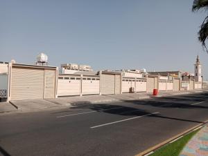 an empty street with a row of fences on the side at شقق لين in Ḑubā
