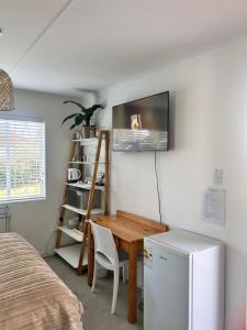 a room with a desk and a table and a refrigerator at Bottlebrush Guest Suite - close to Greenacres Hospital, Free WiFi, Parking, private in Gqeberha
