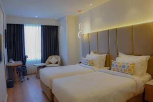 a hotel room with two beds and a window at Best Western AH1 Amritsar in Amritsar +138 photos