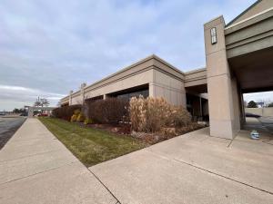 a building with a sidewalk in front of it at Skyline Hotel Detroit Airport, SureStay Collection by Best Western in Romulus