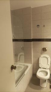 a bathroom with a toilet and a bath tub at Departamento 114 - Edificio VILAUT by INMOVE Temporarios in Córdoba +5 photos