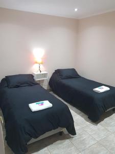 two beds sitting next to each other in a room at Vientos del Sur Esquel in Esquel +1 photo