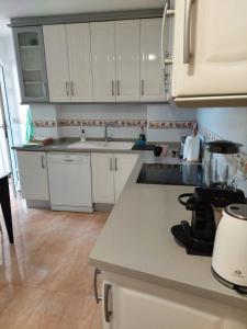 a kitchen with white cabinets and a counter top at Apartamento en Alicante, Plaza de España, zona Mercado, AA in Alicante
