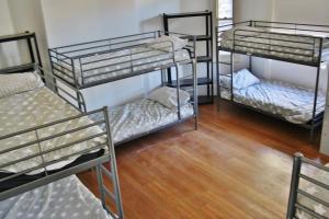 a group of bunk beds in a room with wooden floors at The Hive Hostel - Traveler Friendly, Passport Only in Perth