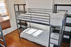 a metal bunk bed with a ladder next to a room at The Hive Hostel in Perth