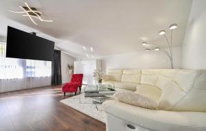 ein Wohnzimmer mit einem weißen Sofa und einem roten Sessel in der Unterkunft 2 Bedroom Amazing Home In Bjelovar in Bjelovar