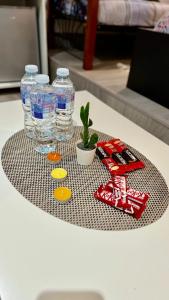 a table with bottles of water and a potted plant at Cozy Home in London