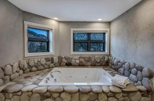 a large bath tub in a room with two windows at $5M Luxury Waterfront Villa - 14 MI to Aspen in Snowmass
