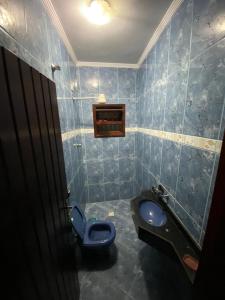 a bathroom with a toilet and a blue tiled wall at Casa na Praia Bertioga in Bertioga +16 photos