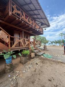 a wooden building with potted plants in front of it at La Bamba in Termales - agua caliente - nuqui
