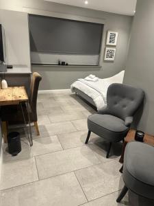 a bedroom with a bed and a chair and a table at Modern Annex in Kent