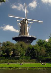 a windmill in a field with people in front of it at Apartement hotel Stays by ADM in Leiden