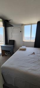 a bedroom with a large white bed and a desk at Ocean View & Pool Family Apartment 2P in Valparaíso