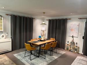 a dining room with a table with yellow chairs at South Bruny Island Retreat in Lunawanna