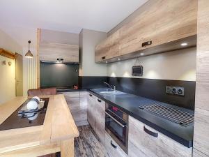 una cocina con fregadero y estufa horno superior en Studio 4 pers à La Clusaz avec Wifi et animaux acceptés - FR-1-818-83, en La Clusaz