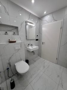 a white bathroom with a toilet and a sink at Modernes Haus mit Garten & Privatparkplatz Villa in Gelsenkirchen +27 photos