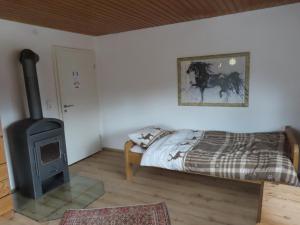 a bedroom with a bed and a wood stove at Monteurwohnung bei Crailsheim Feuchtwangen in Fichtenau