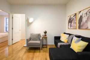 a living room with a black couch and a chair at 109-1 Huge 3BR Best Value - NYC Apt in New York
