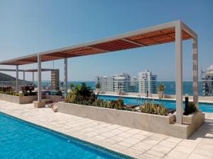 a swimming pool with a pavilion on top of a building at APARTAMENTO EN GAIRA PLAYA SALGUERO SANTA MARTA in Gaira